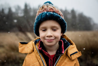 Boy looking out a window holding a cereal bowl at christmas