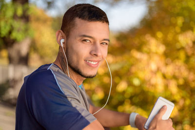 Portrait of young man using mobile phone outdoors
