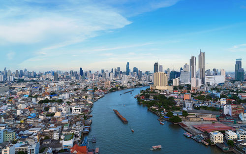 Aerial view of buildings in city against sky