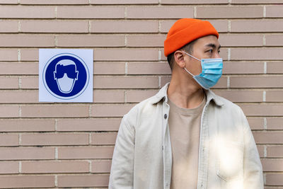 Portrait of man standing against wall