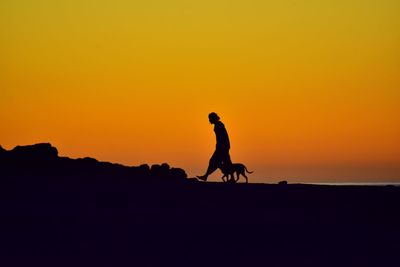 Silhouette man riding horse against sky during sunset