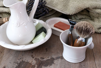 Close-up high angle view of razor and brush in container