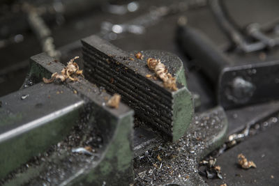 Close-up of metal equipment with wood shavings