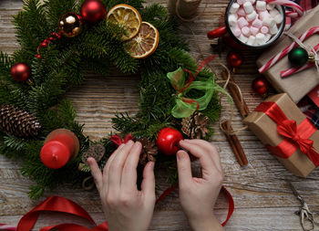 Cropped hand of woman decorating christmas tree