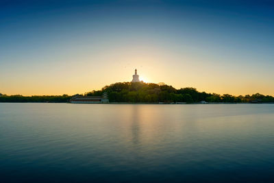 Scenic view of lake against clear sky during sunset