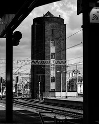 Railroad tracks by buildings in city against sky