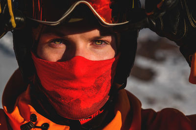 Portrait of a man with yellow eyes. photo of a young serious sportsman in a helmet and ski goggles