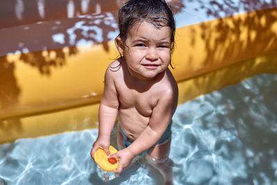 A little girl playing with rubber ducks in the pool. concept of fun