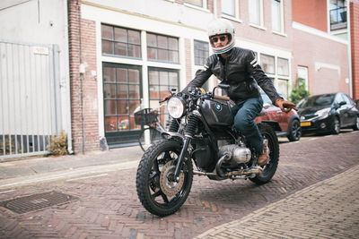 Man riding motorcycle on street in city