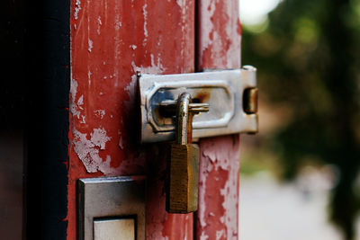 The old rusty padlock on the red door