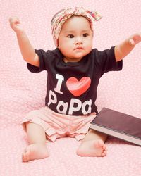 Cute girl sitting on bed at home