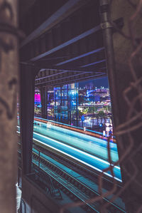 Train in illuminated railroad station at night