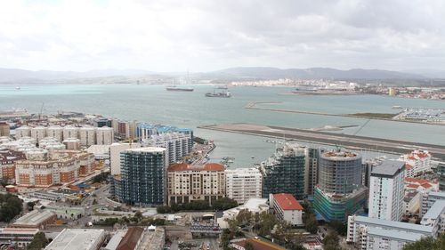 High angle view of city by sea against sky