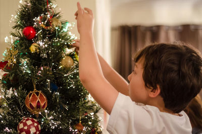 Close-up of christmas decorations hanging on tree at home