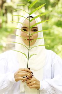 Portrait of woman holding white flowers