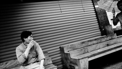 Full length of man sitting outdoors