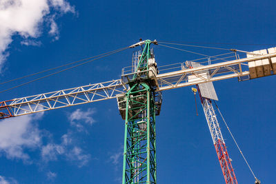 Low angle view of crane against blue sky