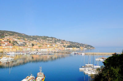 Scenic view of river by townscape against sky