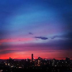 Illuminated cityscape against sky at night