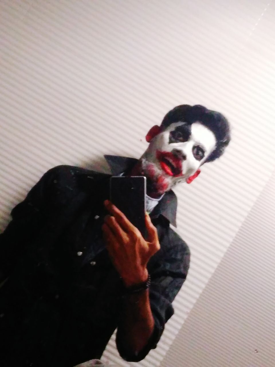 YOUNG WOMAN HOLDING SMART PHONE WHILE STANDING ON CAMERA