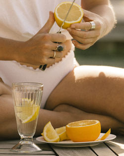 Midsection of woman cutting fruits 