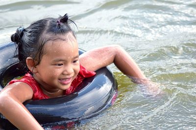 Smiling cute girl swimming in lake