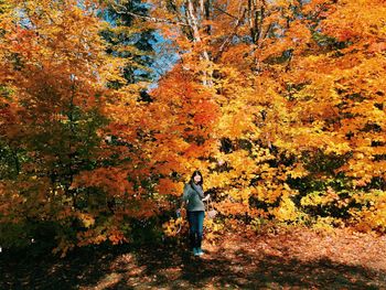 Woman standing on tree trunk