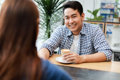 Portrait of a smiling man with drink on table