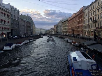 Canal amidst buildings in city against sky