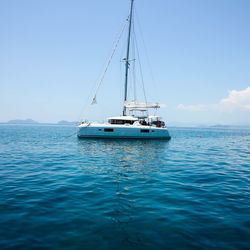 Ship sailing in sea against clear blue sky