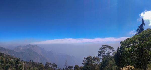 Scenic view of mountains against blue sky