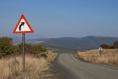 Road signs on landscape against clear sky