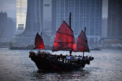 Nautical vessel on sea by buildings in city