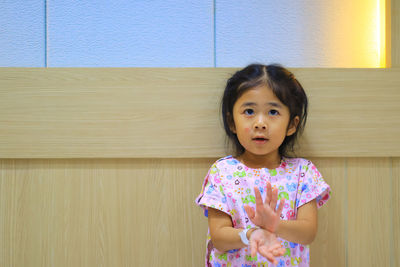 Portrait of cute girl against wall