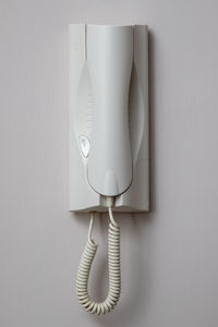 Close-up of telephone against white wall