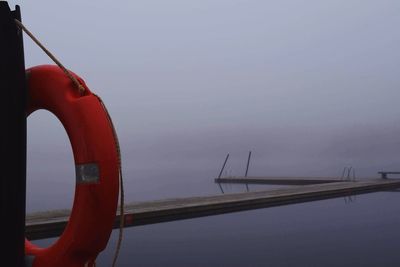 Cropped image of boat moored at harbor against sky