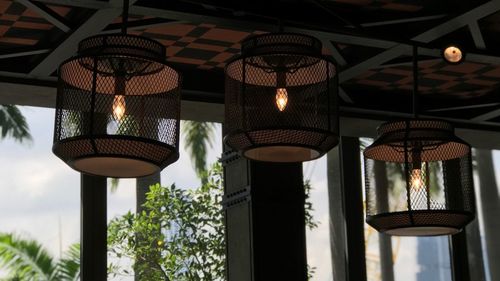 Low angle view of illuminated pendant lights hanging in building