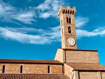 Low angle view of clock tower amidst buildings against sky