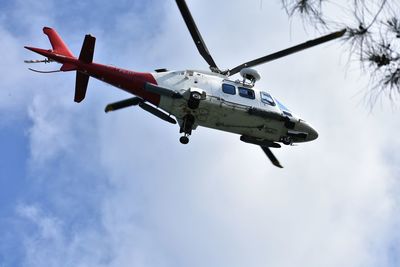 Low angle view of helicopter flying against sky