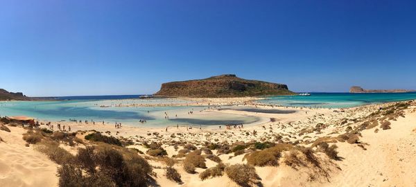 Panoramic view of beach against clear blue sky