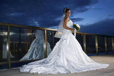 Full length of bride standing by railing