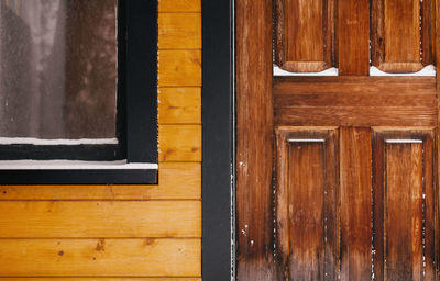 Closeup of wooden house with door and window.