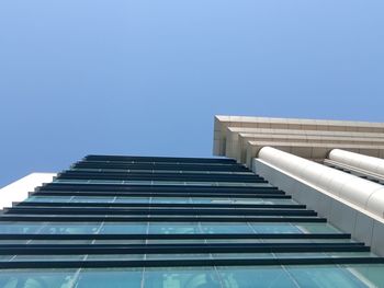 Low angle view of modern building against blue sky