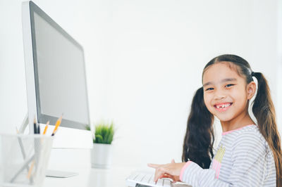 Portrait of a smiling girl sitting on table