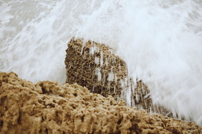 High angle view of waves breaking on rocks at shore