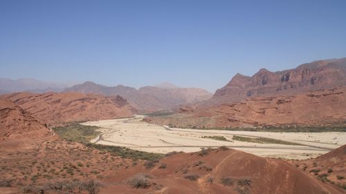 Scenic view of landscape and mountains against clear blue sky