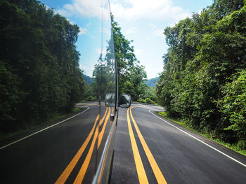 Highway amidst trees against sky