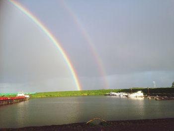Scenic view of rainbow over sea against sky