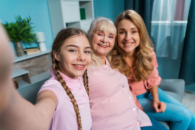 Cheerful girl doing selfie with parents