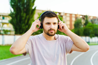 Man listening music over headphones while standing outdoors